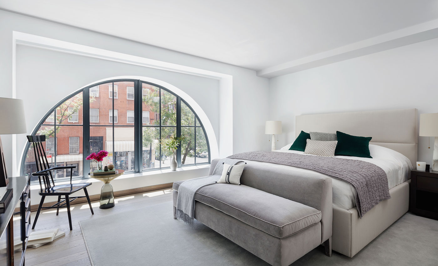 large arched window in open modern bedroom